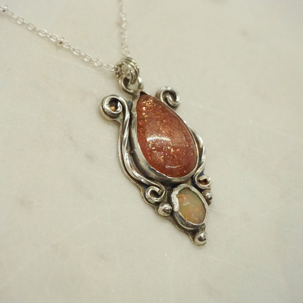 "This stunning Sterling Silver piece, featuring a sparkling Sunstone and mesmerizing Ethiopia Opal, combines industrial-inspired design with vintage charm. The delicate yet sturdy construction makes it the perfect addition to any stylish jewelry collection."