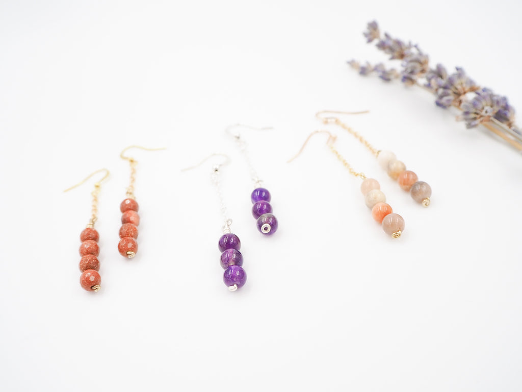 "Adorable gemstone dangle earrings, approximately 2 1/2 inches in length, adding a pop of color and flair to any outfit. Choose between three beautiful gemstones: faceted Goldstone, Amethyst, or Sunstone. These earrings are the perfect way to add a touch of sparkle and color to your look. Each gemstone has its own unique qualities, making these earrings a versatile and stylish accessory for any occasion."